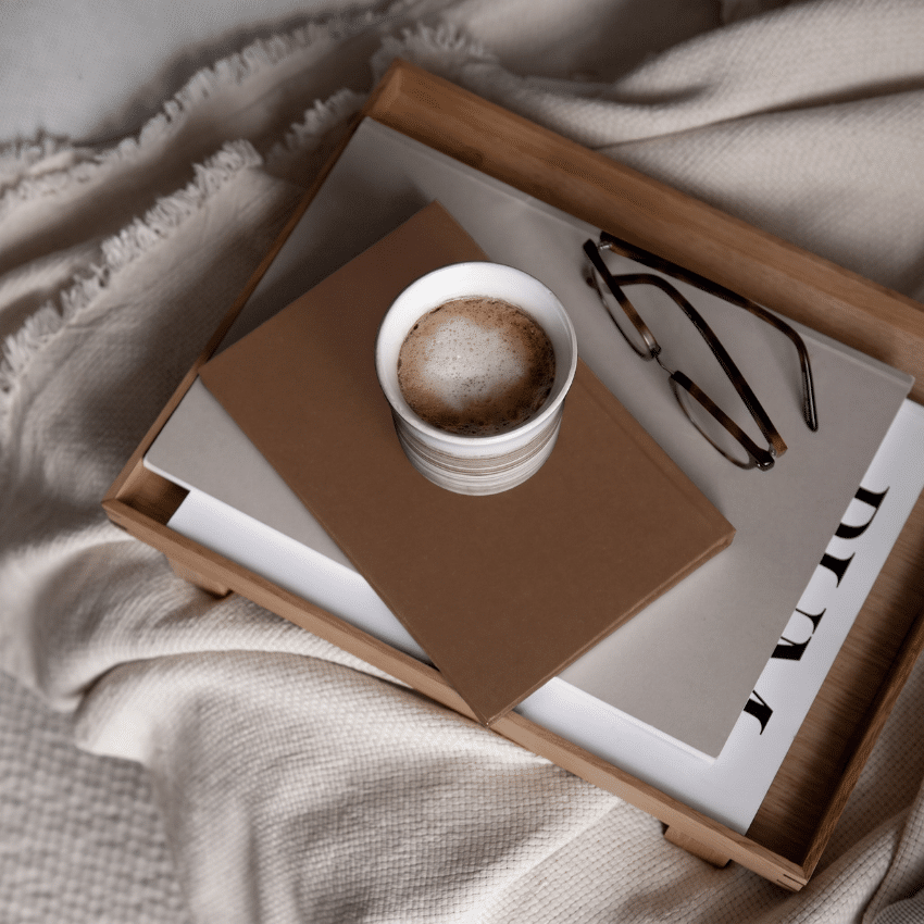 Minimal workspace with a coffee, notebook and glasses representing the customer journey and consistent brand experience across every interaction.